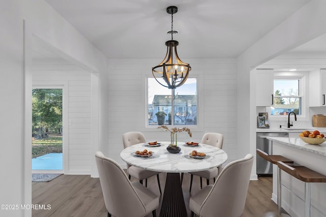 dining area with an inviting chandelier, light hardwood / wood-style flooring, and a healthy amount of sunlight