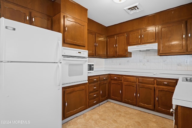 kitchen with white appliances and backsplash