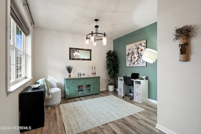 office space featuring light wood-type flooring and a chandelier