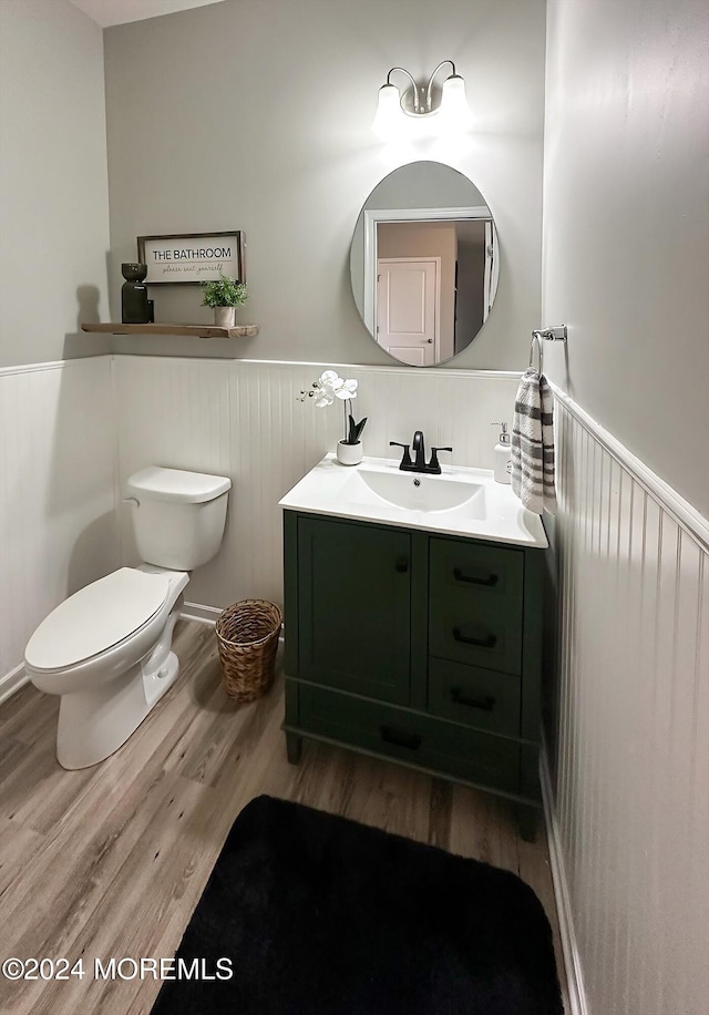 bathroom with wood-type flooring, vanity, and toilet