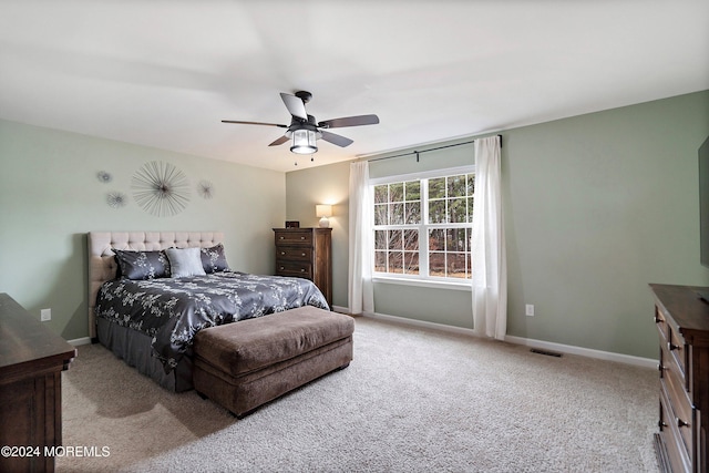 bedroom with ceiling fan and light carpet