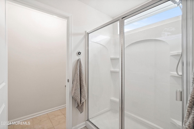 bathroom with tile patterned flooring and a shower with shower door