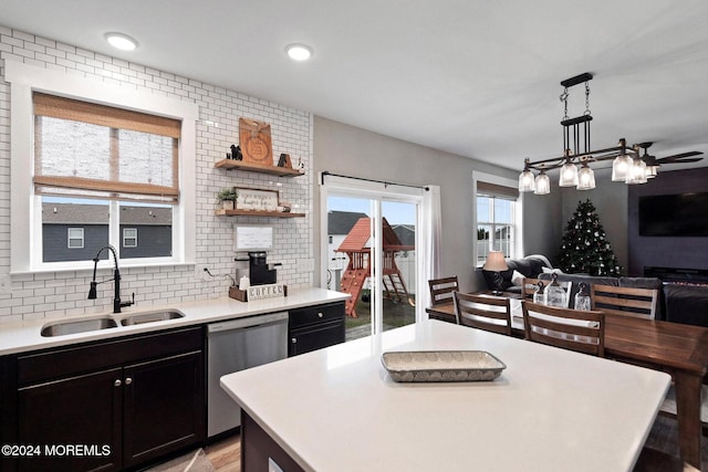 kitchen featuring dishwasher, a wealth of natural light, hanging light fixtures, and sink