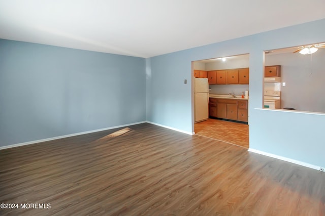 unfurnished living room featuring ceiling fan and light hardwood / wood-style floors