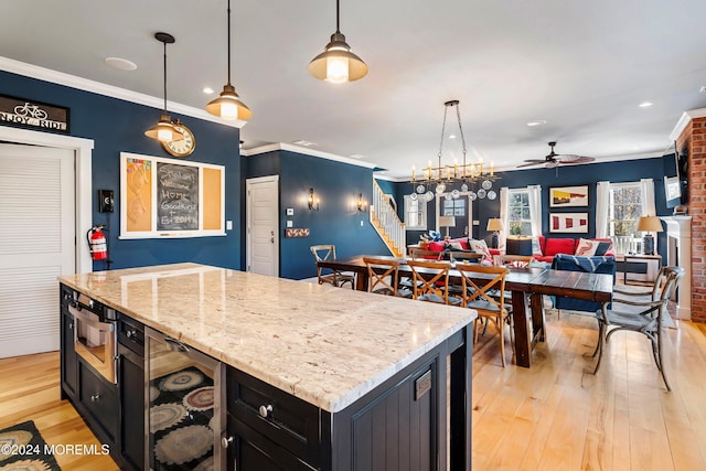 kitchen featuring ceiling fan, hanging light fixtures, and light hardwood / wood-style floors