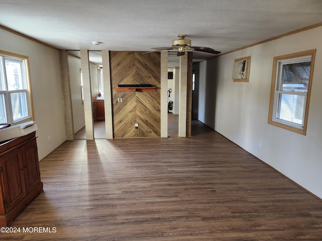 spare room featuring dark hardwood / wood-style floors, ornamental molding, and a textured ceiling