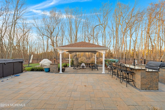 view of patio with a gazebo, exterior kitchen, area for grilling, and an outdoor bar