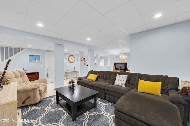 living room featuring a paneled ceiling and a notable chandelier