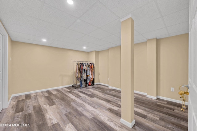 basement featuring a drop ceiling and wood-type flooring