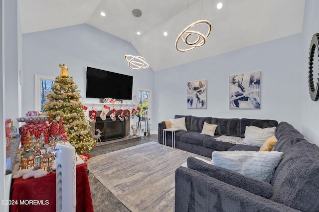 living room featuring hardwood / wood-style floors, high vaulted ceiling, a healthy amount of sunlight, and a notable chandelier