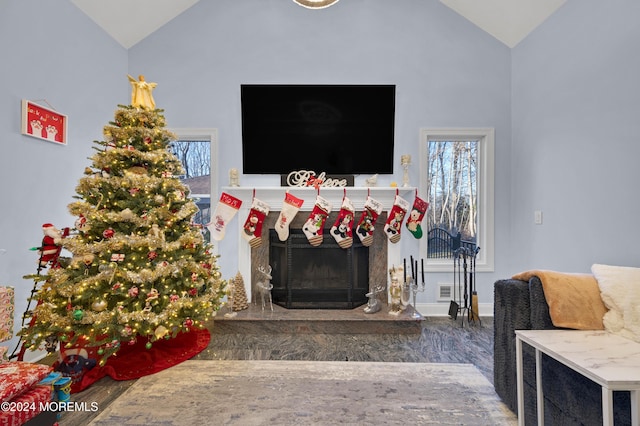 living room with dark hardwood / wood-style flooring, a fireplace, and high vaulted ceiling