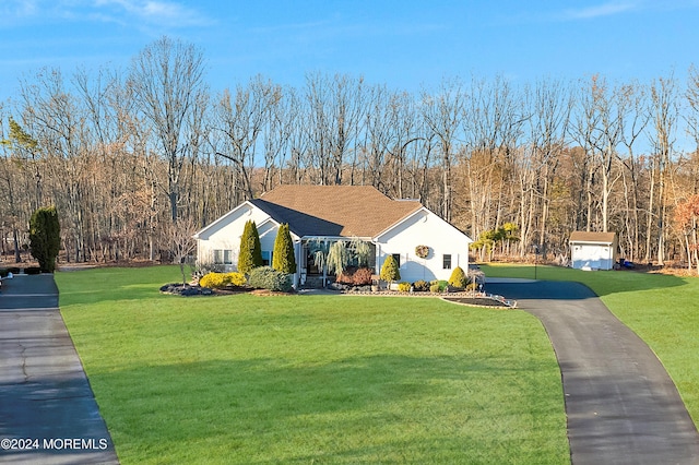 view of front facade with a front yard and a storage unit