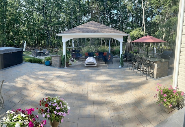 view of patio / terrace featuring exterior bar, a gazebo, and an outdoor hangout area