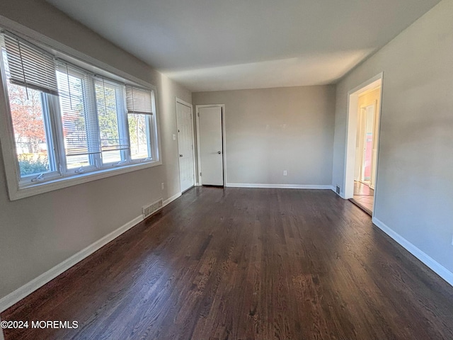 unfurnished room with dark hardwood / wood-style flooring