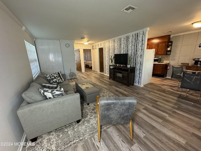 living room featuring wood-type flooring and crown molding