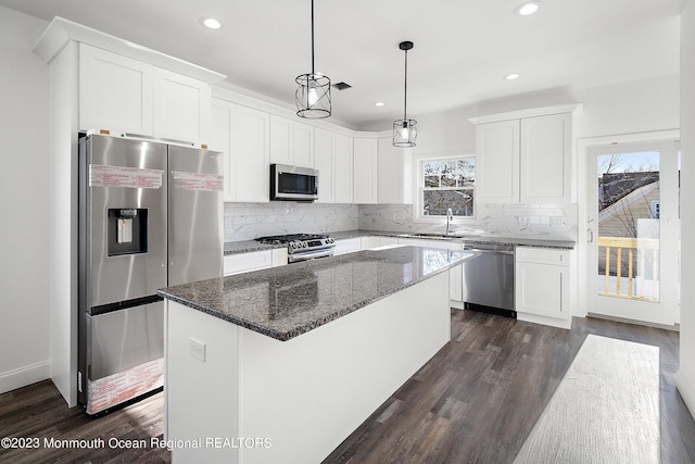 kitchen with white cabinets, appliances with stainless steel finishes, and a center island