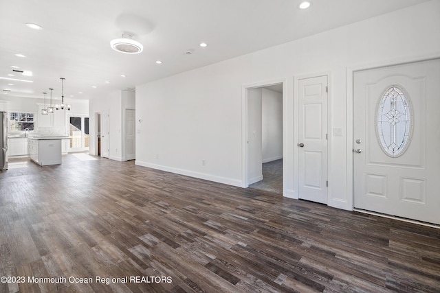 unfurnished living room featuring dark hardwood / wood-style floors and a notable chandelier