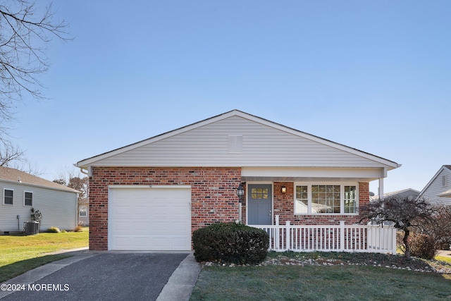 view of front of house with a garage, covered porch, central air condition unit, and a front yard