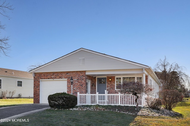 single story home with a porch, a garage, and a front yard