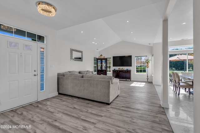 living room with light hardwood / wood-style flooring and high vaulted ceiling