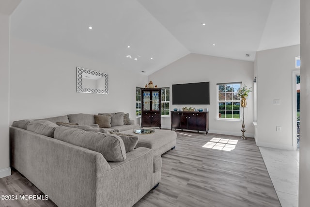 living room with high vaulted ceiling and light hardwood / wood-style flooring