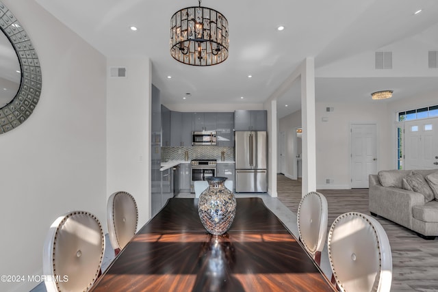 dining room with light hardwood / wood-style floors and an inviting chandelier