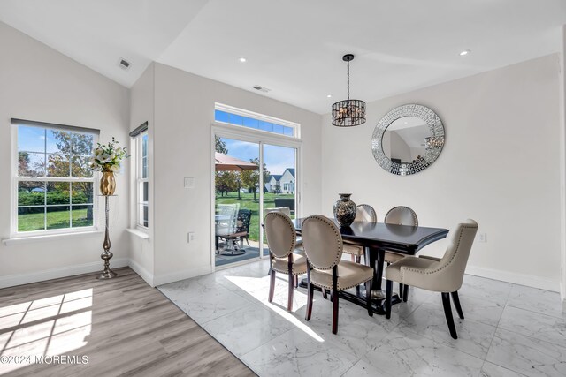 dining area with a notable chandelier and lofted ceiling