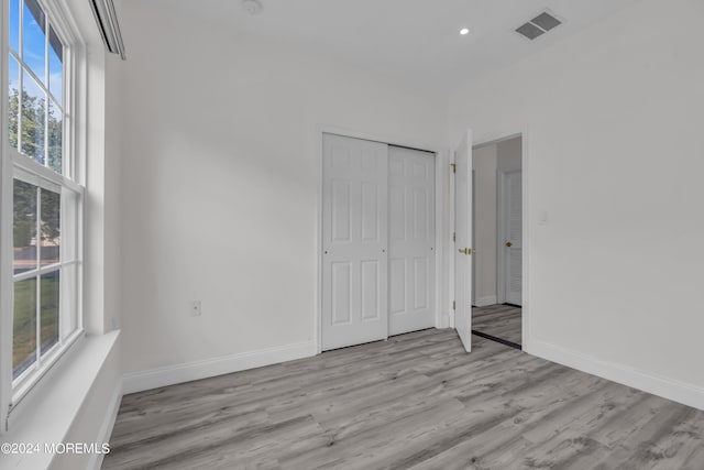 unfurnished bedroom featuring light hardwood / wood-style flooring and a closet