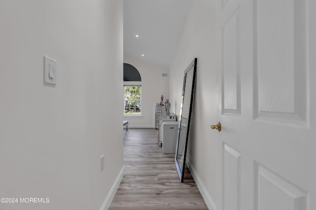 hall featuring vaulted ceiling and light wood-type flooring