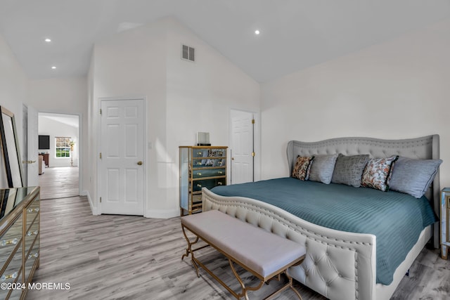 bedroom featuring high vaulted ceiling and light hardwood / wood-style floors