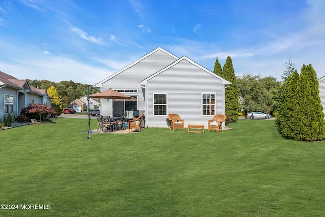 rear view of property with a yard and a patio