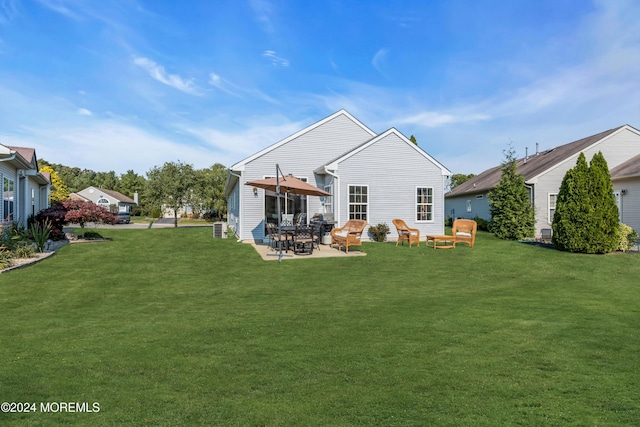 back of property with a patio area and a yard