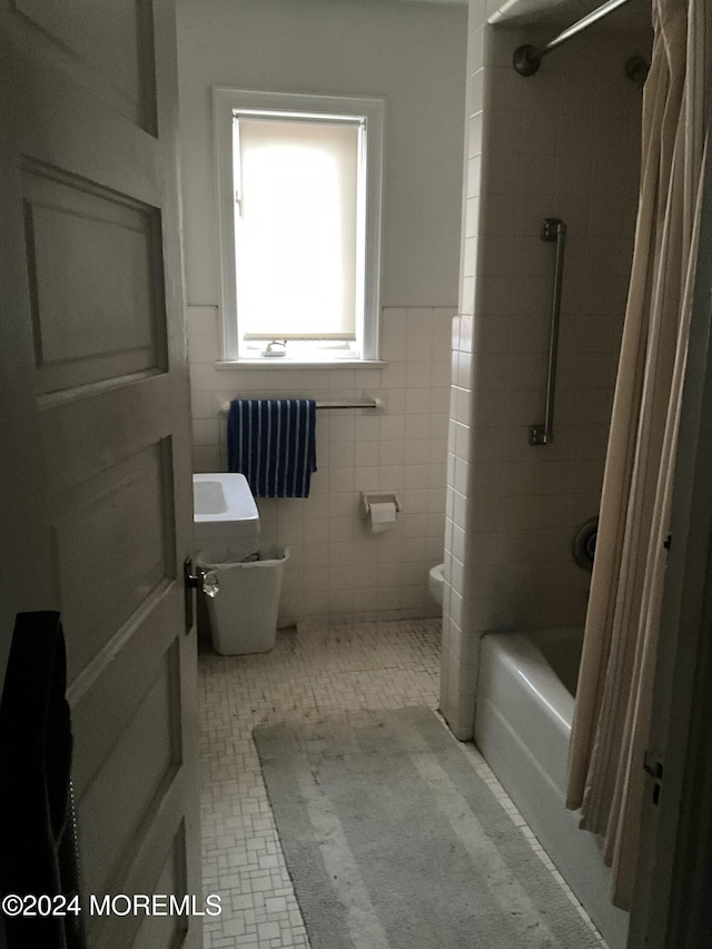 bathroom with tile patterned floors, shower / bath combo, toilet, and tile walls