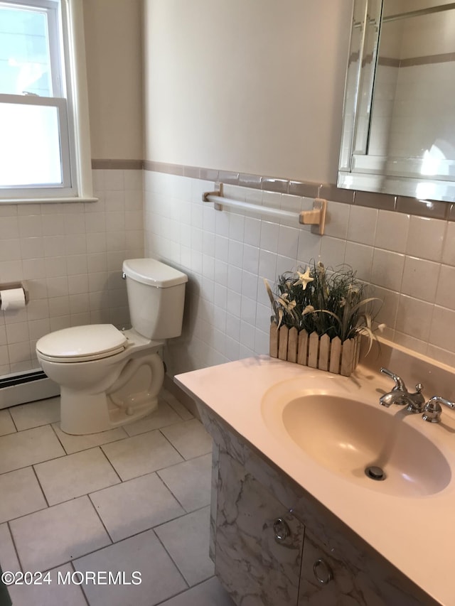 bathroom with toilet, tile patterned floors, baseboard heating, and tile walls