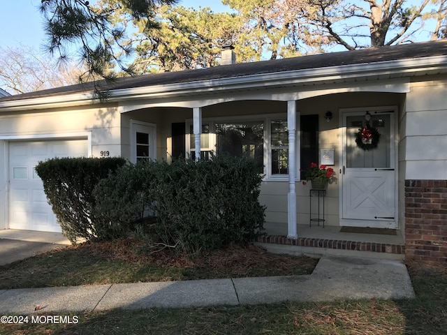 entrance to property with covered porch and a garage