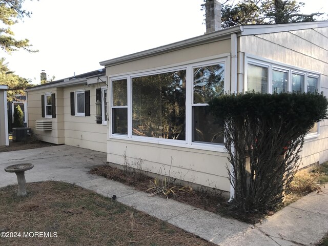 view of side of home featuring a patio and central AC