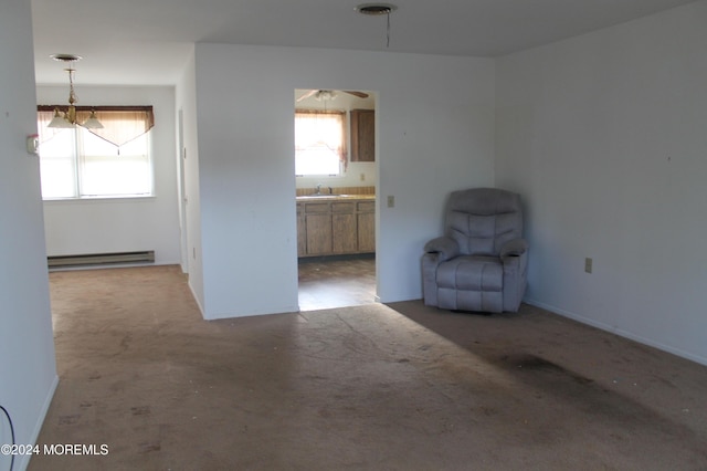 unfurnished room with carpet flooring, a baseboard radiator, and sink