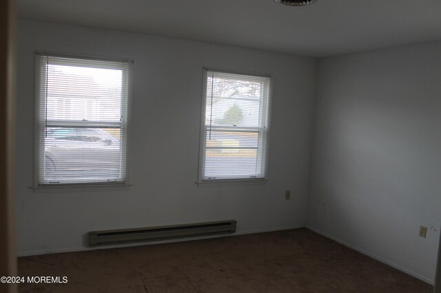 empty room with a baseboard radiator and a wealth of natural light