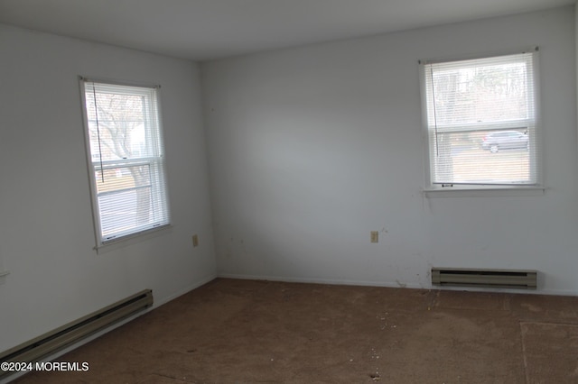 unfurnished room featuring carpet and a baseboard heating unit