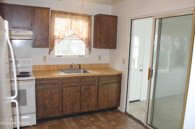 kitchen featuring white range with electric cooktop, ventilation hood, and sink