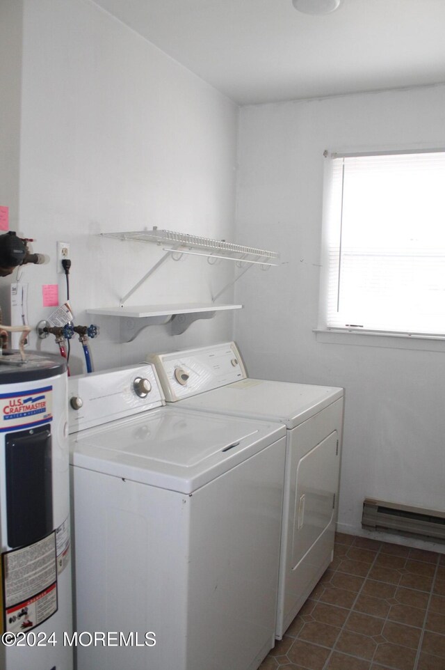 clothes washing area with electric water heater, dark tile patterned floors, a baseboard radiator, and washing machine and dryer