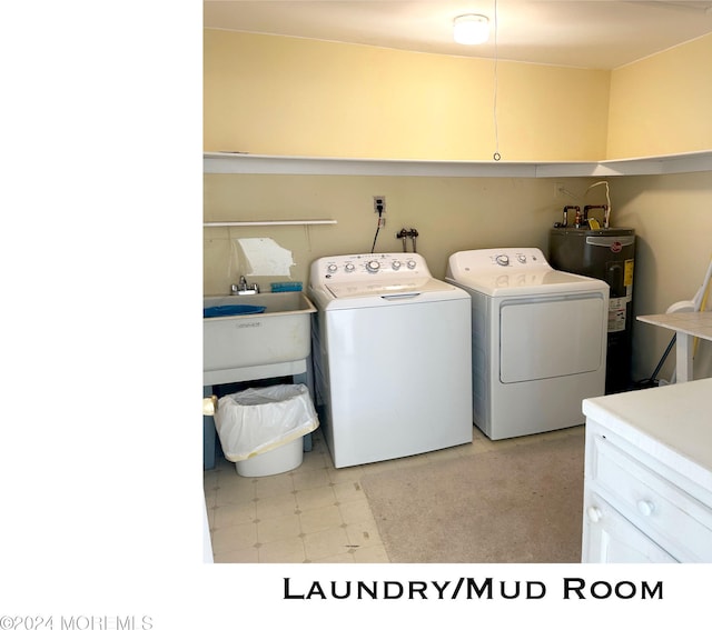 laundry room featuring cabinets, electric water heater, washer and clothes dryer, and sink