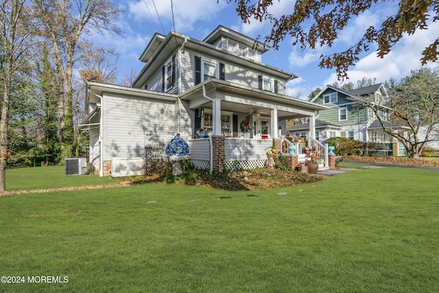 view of front of home featuring a front lawn, cooling unit, and covered porch