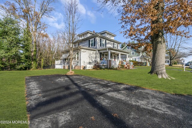 view of front of property featuring a porch and a front lawn