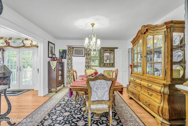 dining area featuring french doors, an inviting chandelier, and light wood-type flooring