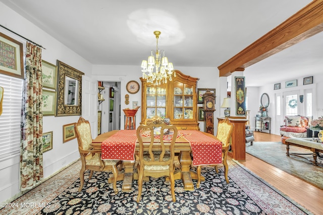 dining room featuring a chandelier, beamed ceiling, and wood-type flooring