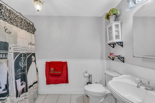 bathroom featuring tile patterned flooring, toilet, and sink