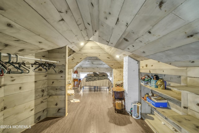 interior space with wooden walls, hardwood / wood-style floors, and vaulted ceiling