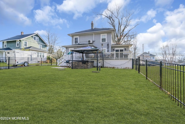 rear view of house featuring a gazebo and a lawn