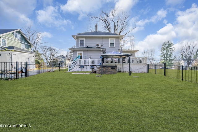 back of property featuring a gazebo, a deck, and a lawn